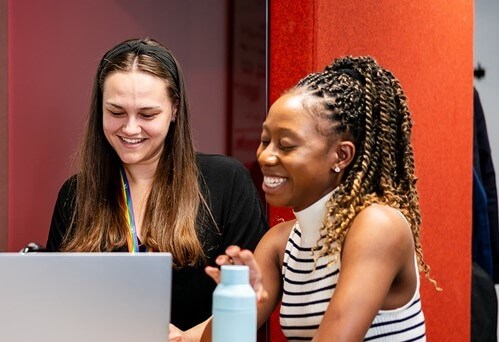 Two women working together on a laptop