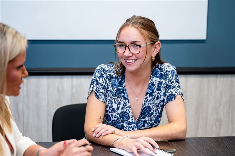 Two women talking in a bright meeting room