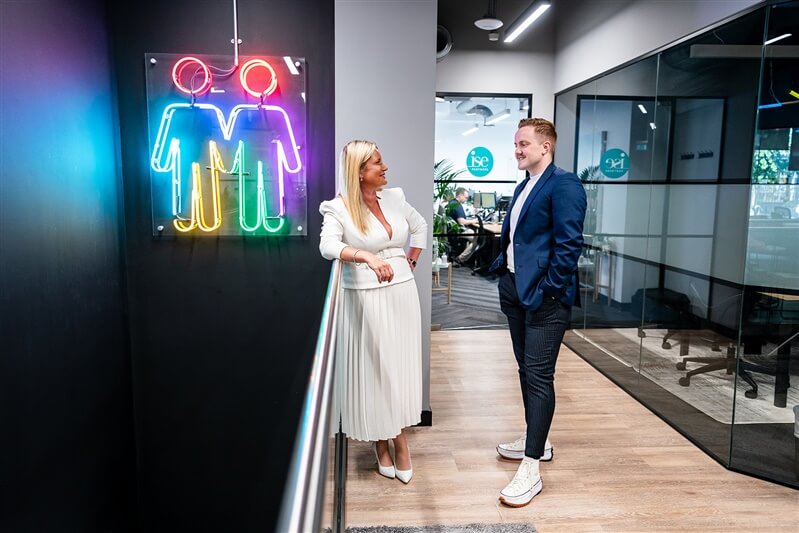 Two people talking in an office hallway