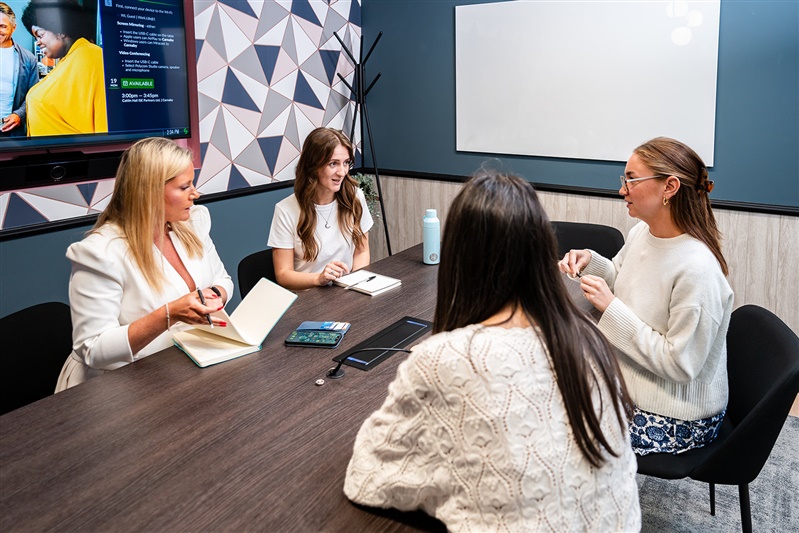 Group of women in a meeting, colourful meeting room.